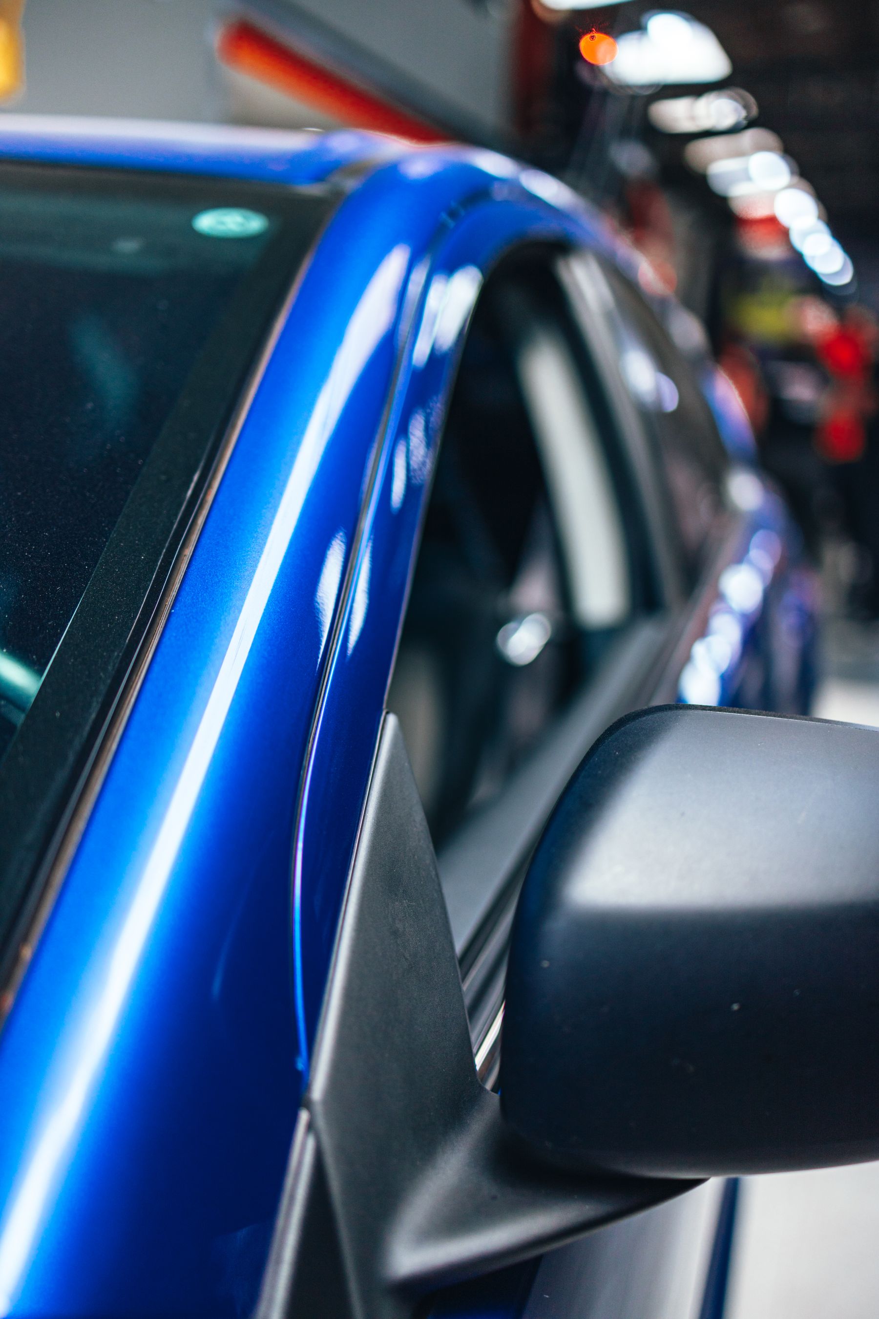Stock photo of a clean blue car finish and side mirror